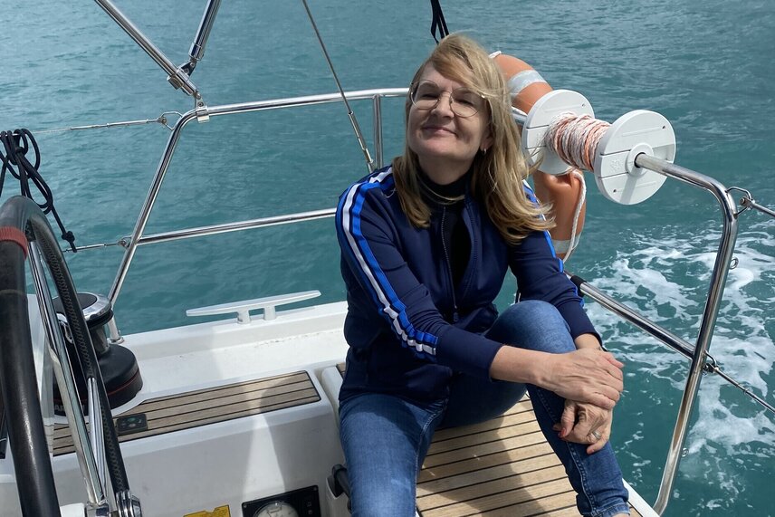 Eine Frau sitzt am Hinteren Ende des Schiffes und lächelt und posiert für die Kamera Eine Frau sitzt am Hinteren Ende des Schiffes und lächelt und posiert für die Kamera