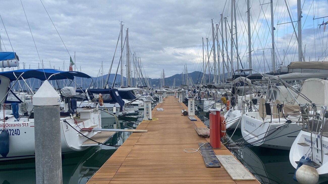 ein Steg an dem viele Boote zu sehen sind, bewölter Himmel